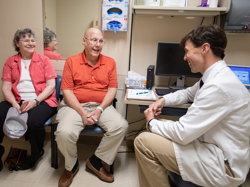 Dr. Clark Henegan, assistant professor of hematology and oncology, talks to patient Paul Gay and his wife, Dr. Hannah Gay, about results of a recent prostate cancer PET/CT scan.